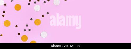 Golden and silver confetti scattered on a purple pastel background. Festive concept. Stock Photo
