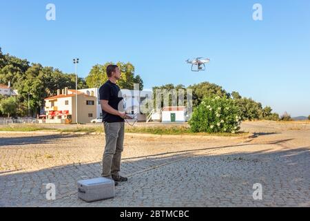 Man, an engineer pilot, prepares air device for take-off, for testing and filming a vileo and photograph. By controlling the remote. Stock Photo