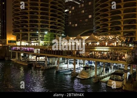 Night horizontal view of the restaurants and bars by the Marina City towers with the Chicago River yacht dock at their feet, Chicago, Illinois, USA Stock Photo