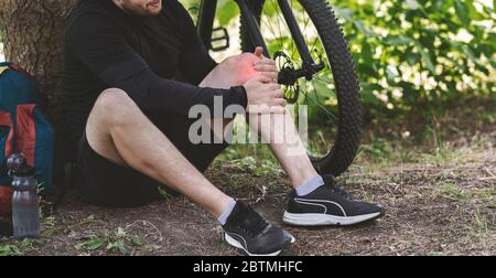 Young man having pain in his knee Stock Photo