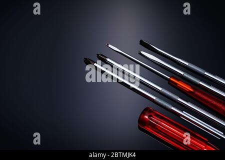 Screwdriver and center punch. Mechanic hand tools. Screwdriver sets with interchangeable blades. Mobile tools set. Tools set on black background. Stock Photo