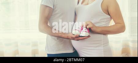 Pregnant woman and man baby shoes. Selective focus. nature Stock