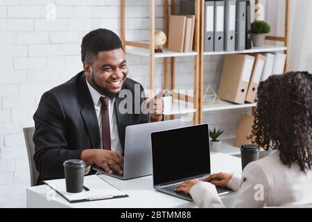 Teamwork and collaboration. Smiling colleagues having friendly communication at workplace Stock Photo