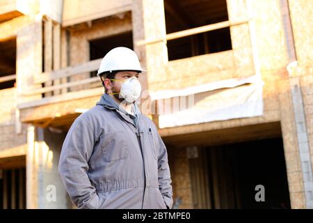Architect wearing respirator near brick building. Stock Photo