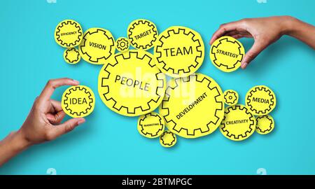 Collage of people holding gears with business related words on blue background Stock Photo