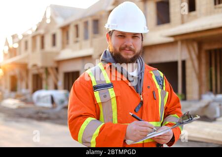 European architect writing in notebook on construction site. Stock Photo