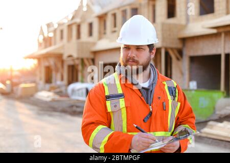 Engineer writing in notebook on construction site. Stock Photo