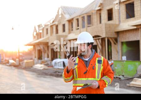 Foreman talking by walkie talkie on construction site. Stock Photo