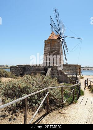 a old windmill that was used to make salt from the sea in Sicily Stock Photo