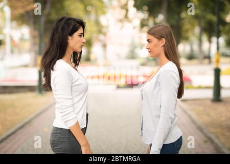 Two Girls Friends Having Conflict Standing Outdoors After Quarrel Stock Photo