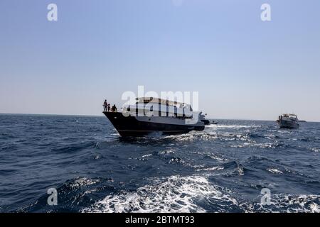 Hurghada, Egypt - september 17, 2019: Unknown people on white yacht watching dolphins in the Red sea, Jaz 'ir Jift n Stock Photo