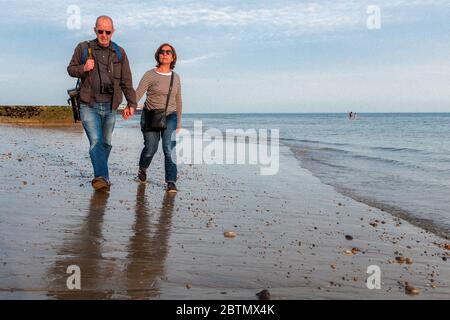 Couple Walk Along Brighton Beach During The Coronavirus Lockdown, Brighton & Hove, England Stock Photo