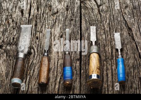 Carpenter tools composition. Old carpenter chisels laying on rustic wooden table upper view Stock Photo