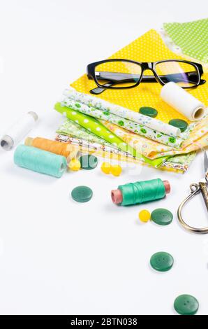 Sewing set with fabric, spools of thread, scissors and glasses Stock Photo