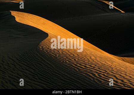 a chiaroscuro pattern at sunset in the magnificent Maspalomas dunes, located in the south of Gran Canaria island Stock Photo