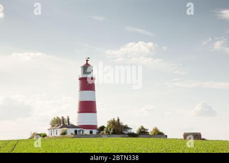 looking across a field at Happisburgh in Norfolks at the lighthouse Stock Photo