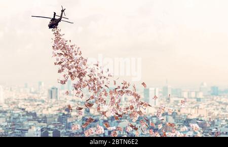 helicopter flies over the city and distributes euro money to everyone. Helicopter money concept. Financial aid in times of crisis coronavirus covid 19 Stock Photo