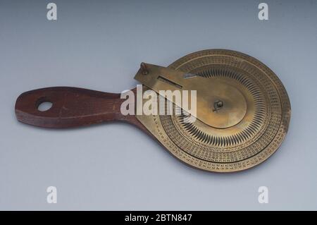 Hatfield Machine for Adding Numbers. This patent model for an adder with mechanical carry has a wooden handle and circular base on which three concentric brass discs and a brass arm are mounted. Stock Photo