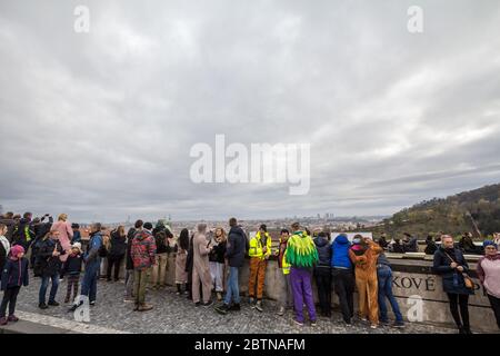 PRAGUE, CZECHIA - NOVEMBER 2, 2019: Crowd of tourists, packed, observing an aerial panorama of Prague, Czech Republic, seen from the top of the castle Stock Photo