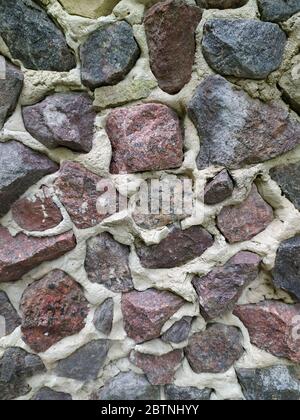 Gray, brown, black stone wall background, granite mosaic stonewall rubble facade closeup texture Stock Photo