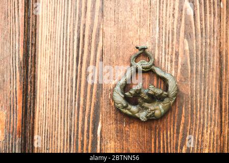 Wooden door with knocker. Surface texture. Abstract grunge bright color background with aging effect. Copyspace Stock Photo