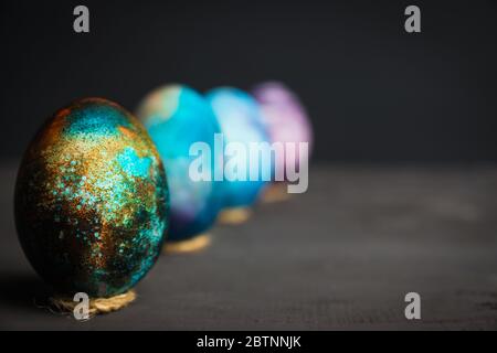 Rustic colored easter eggs on the dark stone background. Shallow depth of field. Stock Photo
