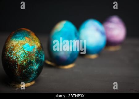 Rustic colored easter eggs on the dark stone background. Shallow depth of field. Stock Photo