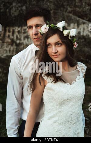 happy elegant groom and  stylish boho bride posing at sunset in the mountains Stock Photo