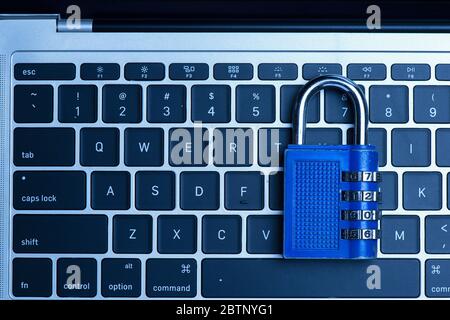 Computer security concept with a closed ฺBlue padlock on top of the keyboard Stock Photo
