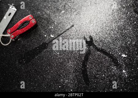 A set of tools for self-installation of the lamp lies on a black table, sprinkled with white dust. Husband for an hour. Household chores Stock Photo