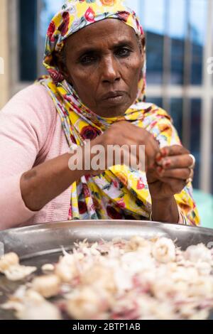 Portrait of muslim woman processing food in the market of Bati, Amhara Region, Oromia, Ethiopia, Africa Stock Photo