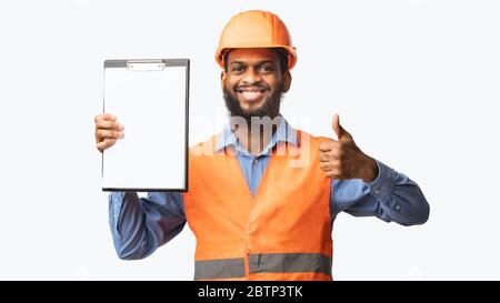 African Construction Worker Showing Folder Gesturing Thumbs-Up, White Background, Panorama Stock Photo