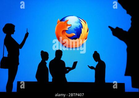 NEW YORK, USA, 25. MAY 2020: Mozilla Firefox web browser Group of business people chat on mobile phone and laptop. Company logo on screen in backgroun Stock Photo