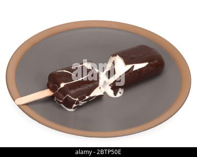 Ice cream covered with chocolate, broken in a plate Stock Photo