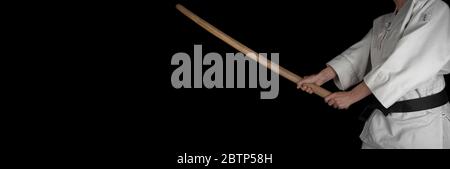 A person practicing aikido on a black background. Stock Photo
