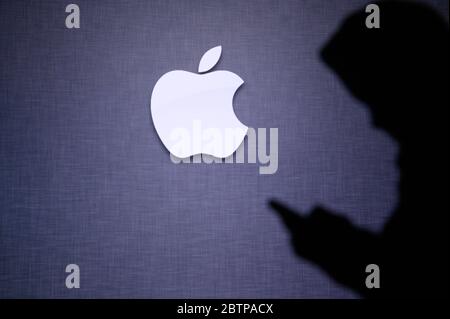 NEW YORK, USA, 25. MAY 2020: Apple American multinational technology company Young boy chat on mobile phone. Company logo on screen in background Stock Photo