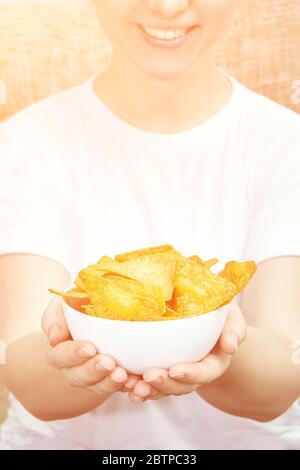Girl holding at hands chips bowl. Stock Photo