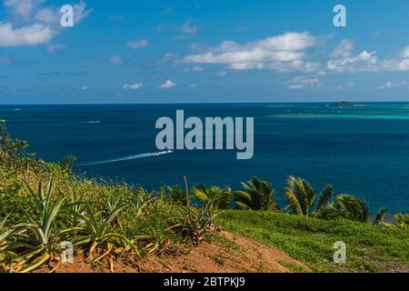 Looking over the edge of an island. Endless deep blue sea with an boat in it Stock Photo