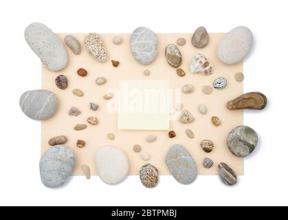 Sticky notes in the middle of mix of rounded multicolor textured stones on beige paper background . Isolated flat lay with copy space Stock Photo