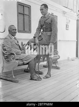 Fiji Islanders arrive for Coronation. Capt Sukuna and Lt Cakobou, of the Fiji defence force, arrived at Tilbury on the liner 'RMS Strathnaver' to represent the Fiji Islands at the Coronation. Photo shows,Lt Cakobou (who wears a skirted uniform with sandals), talking with Capt Sukuna (seated) on arrival at Tilbury. 30 April 1937 Stock Photo