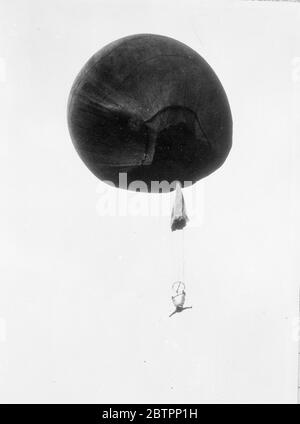 Trapeze act in the air. Suspended by his heels from a balloon hundreds of feet in the air, Warren Allen, Jr, aged 33, of Batavia, New York, defied death to provide thrills for the crowds at Cortland County Centennial Fair. Alan is carrying on, despite the fact that his cousin was killed in a parachute jump from a plane a year ago. 5 September 1938 Stock Photo