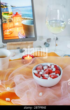 Still life with strawberries, coffee and a glass of white wine and a photo of a seaside resort Stock Photo