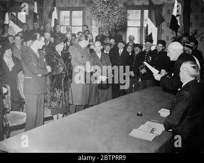 Josephine Baker marries French businessman. Unknown to her friends, Josephine Baker, the famous dancer, was married quietly at crevecoeur le Grand in the Department of the Oise to M Jean Lion, a young French businessman and aviator. The Mayor of Crevecoeur performed the ceremony and M Derval, director of the Folies Bergere was a witness. Miss Baker is coming to London in a few days time. Photo shows, the Mayor of Crevecoeur performing the ceremony. Josephine Baker and her groom are on left (smiling) over table hangs a huge bunch of mistletoe, 30 November 1937 Stock Photo