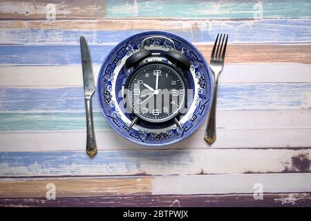 the concept of Healthy Food, alarm clock on plate  Stock Photo