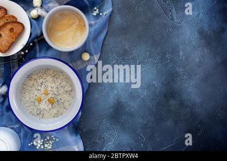 oatmeal porridge with Chia seeds and raisins, coffee and pastries on a dark blue background with copy space Stock Photo