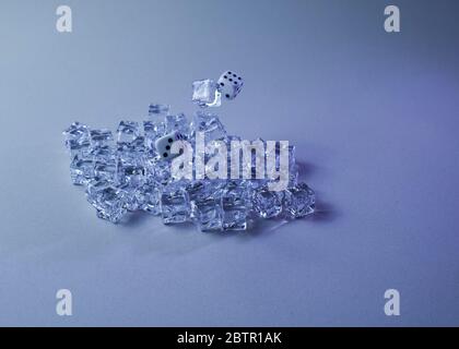 Set of ice cubes and dice falling on them, gray background, chaos Stock Photo
