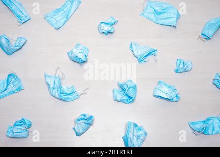 Used medical mask thrown away. Utilization of protection during coronavirus. Protective facemasks scattered on the floor. Background of used medical Stock Photo