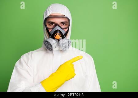 Close-up portrait of his he nice serious content professional disinfectant doctor wearing gas mask pointing forefinger aside way direction advert news Stock Photo