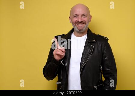 Portrait of stylish handsome man smiling and pointing aside Stock Photo