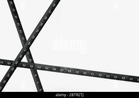 Black Measure tape isolated on white background. Weight loss, diet, overweight concept. Copy space Stock Photo